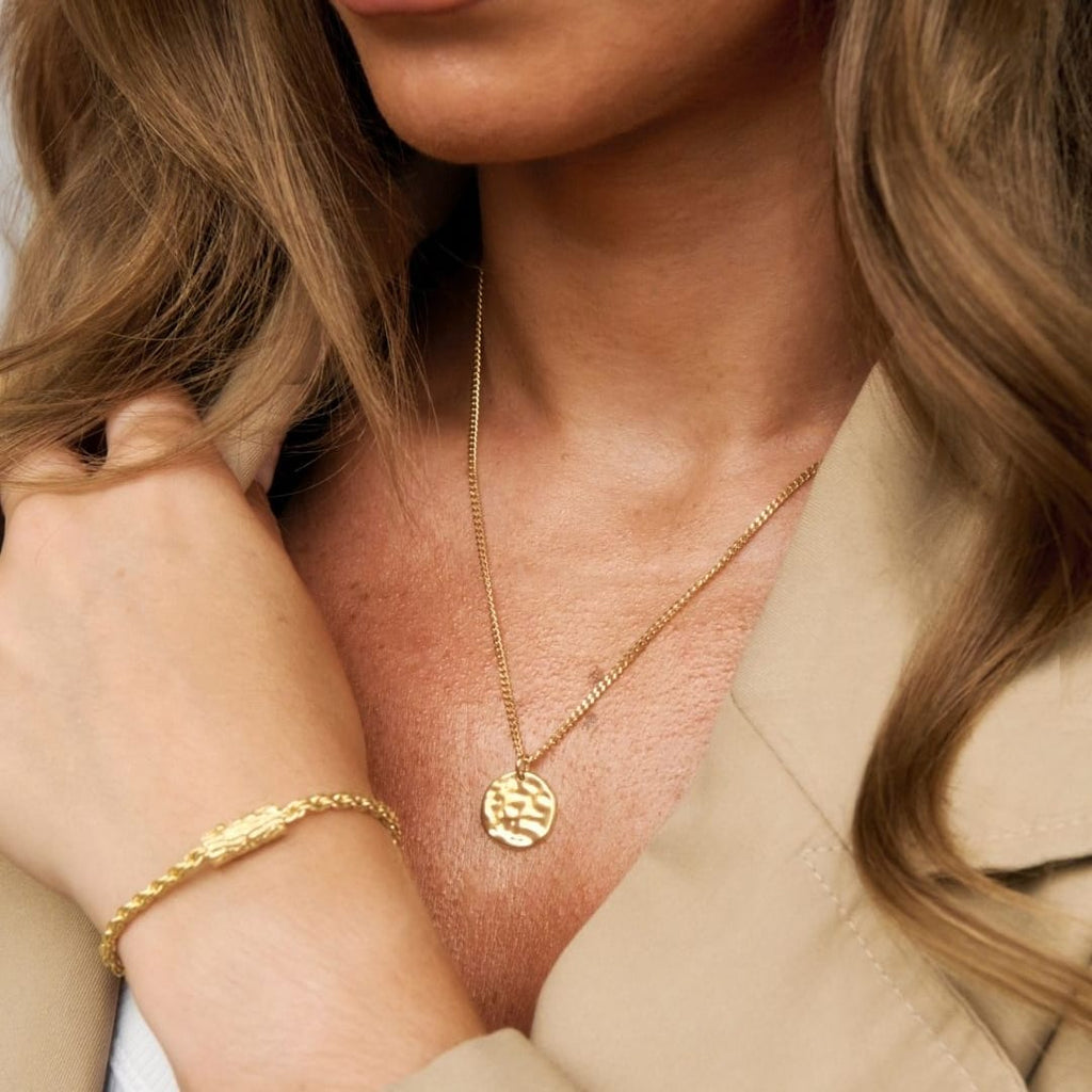 gold pendant being worn
